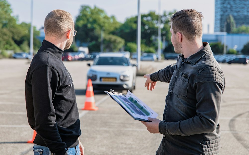 Driving test examiner with a tablet next to a learner